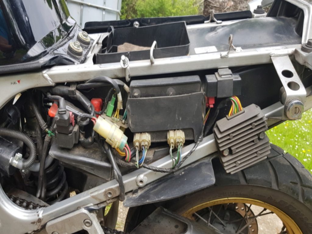 Boîtier CDI monté sous la selle, avec faisceau et connecteurs visibles